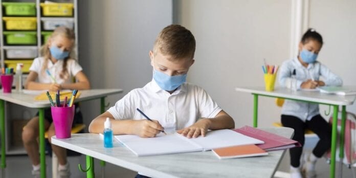 kids-writing-classroom-while-wearing-medical-masks